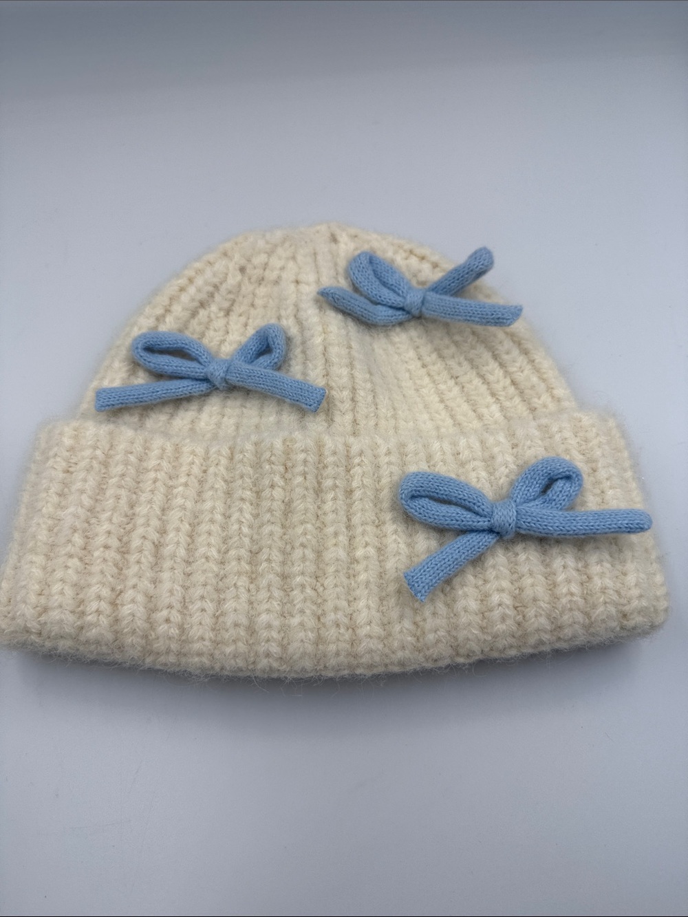 Cream Knit Beanie with Light Blue Bow Accents